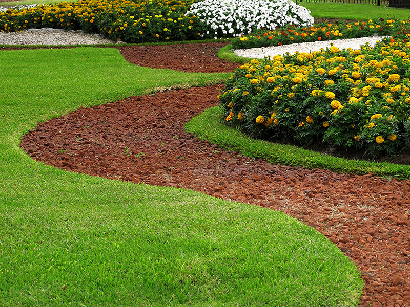 flower bed surrounded by red mulch and lawn